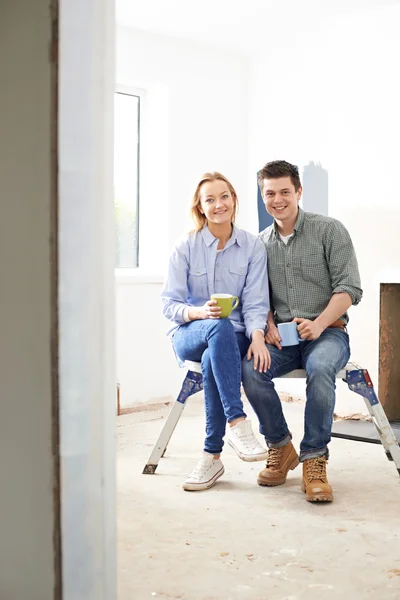 Junges Paar sitzt in Anwesen, das renoviert wird — Stockfoto