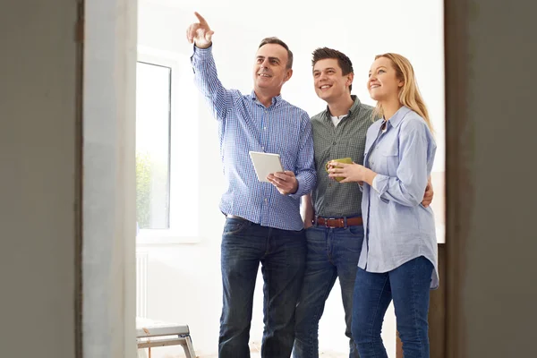 Encontro de casal com arquiteto ou construtor em propriedade renovada — Fotografia de Stock