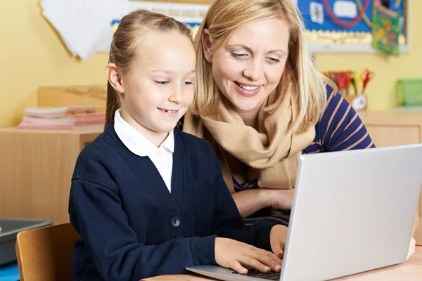 Teacher Helping Female Elementary School Pupil In Computer Class — Stock Photo, Image
