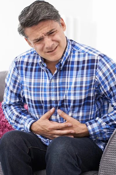 Uomo maturo che soffre di dolore allo stomaco a casa — Foto Stock