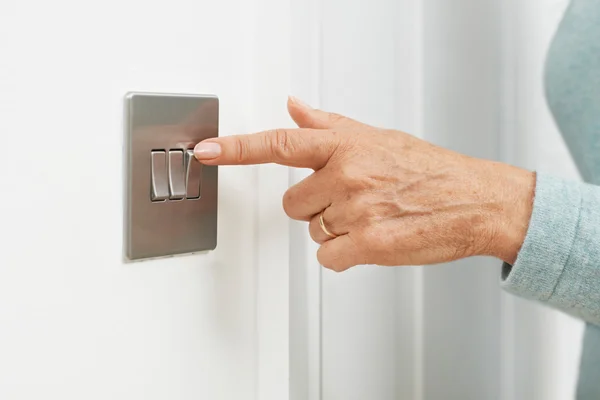 Primer plano de la mujer apagando el interruptor de luz — Foto de Stock