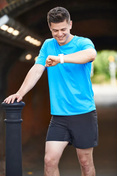 Man Looking At Activity Tracker Whilst Exercising In Urban Setti — Stock Photo, Image