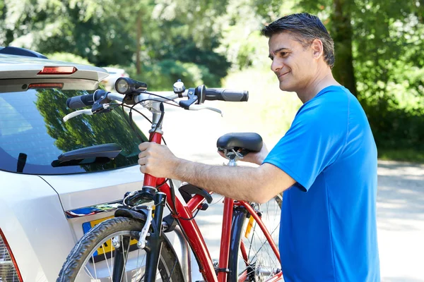 Maduro ciclista masculino tomando bicicleta de montaña de bastidor en el coche — Foto de Stock