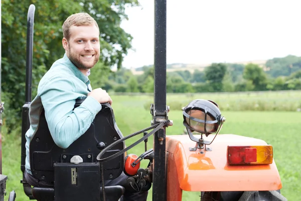 Retrato del agricultor sentado en el tractor en el campo —  Fotos de Stock