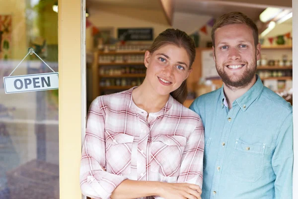 Porträtt av par kör delikatessbutik utanför butiken — Stockfoto