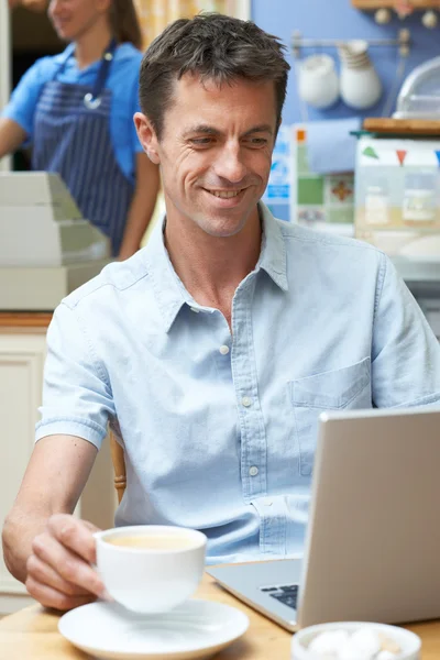 Uomo in caffetteria utilizzando computer portatile — Foto Stock