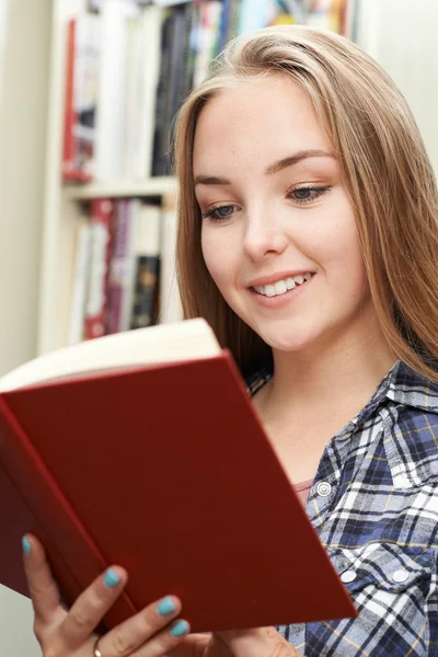 Tonårig flicka läsa bok hemma — Stockfoto