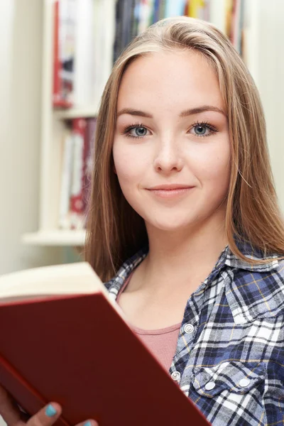 Tonårig flicka läsa bok hemma — Stockfoto