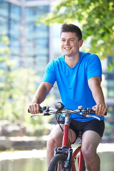 都会の川の横にある自転車の若い男 — ストック写真