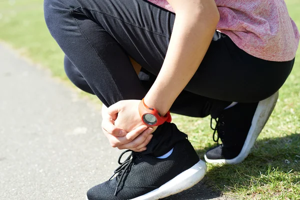 Mulher com lesão esportiva sustentada enquanto jogging no parque — Fotografia de Stock