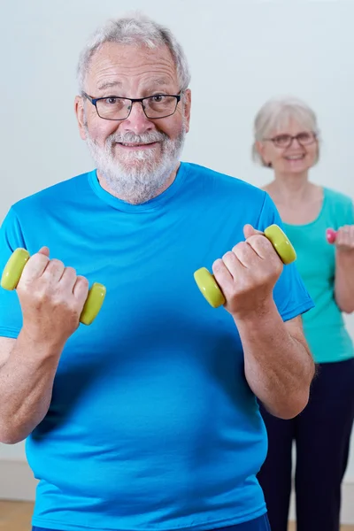 Pareja mayor en clase de fitness usando pesas — Foto de Stock