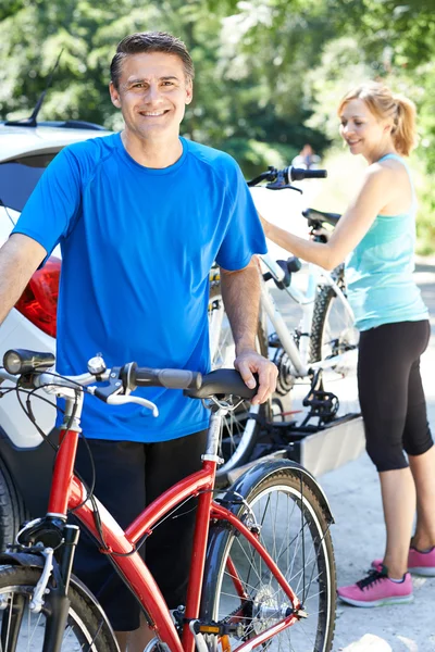 Couple d'âge mûr prenant des vélos de montagne de rack sur la voiture — Photo