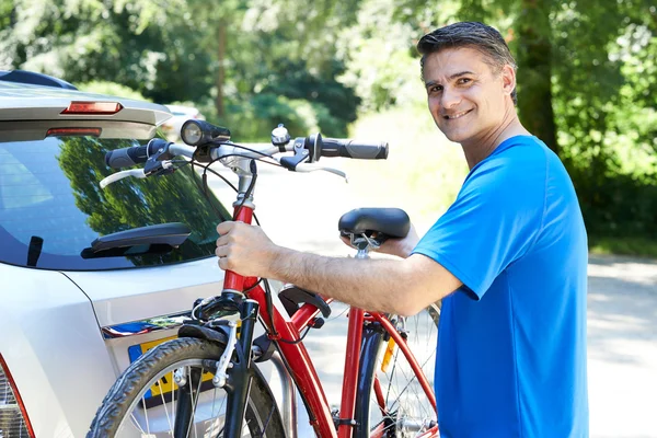 Mature Male Cyclist Taking Mountain Bike From Rack On Car — Stock Photo, Image