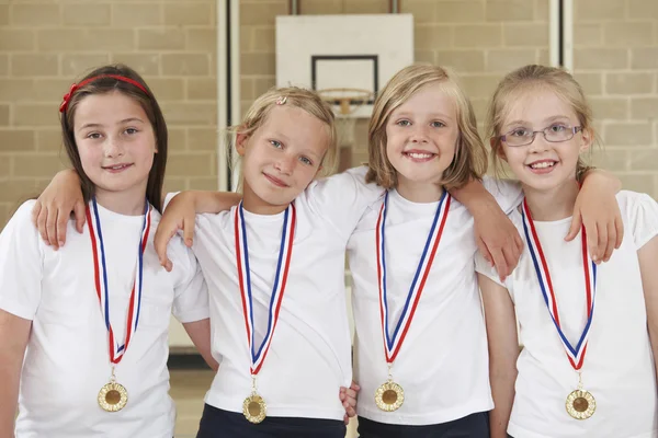 Αθλητική ομάδα κοριτσιών της εκπαίδευσης στο γυμναστήριο με μετάλλια — Φωτογραφία Αρχείου