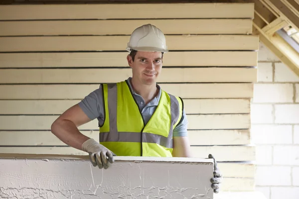 Construtor montagem placas de isolamento para telhado da nova casa — Fotografia de Stock