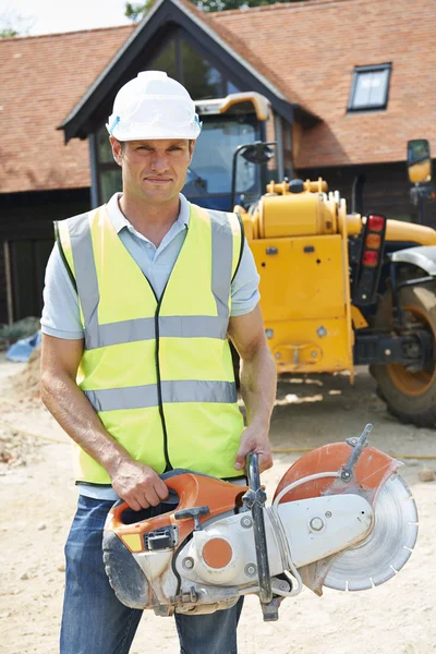 Obrero de la construcción en el sitio que sostiene la sierra circular — Foto de Stock