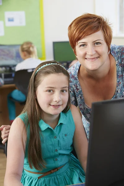 Vrouwelijke elementaire leerling van computer klas met leraar — Stockfoto