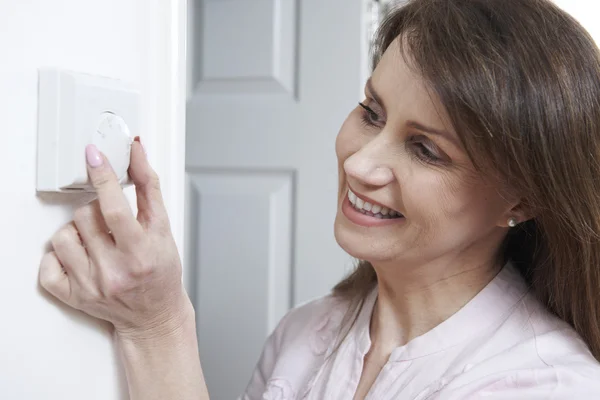Mulher ajustando termostato no controle de aquecimento central — Fotografia de Stock