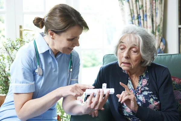 Медсестра консультирует пожилую женщину по вопросам медикаментов дома — стоковое фото