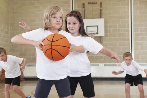 Alunos da escola primária jogando basquete no ginásio — Fotografia de Stock