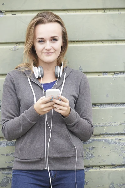 Tonårsflicka bär hörlurar och lyssna på musik i urban — Stockfoto