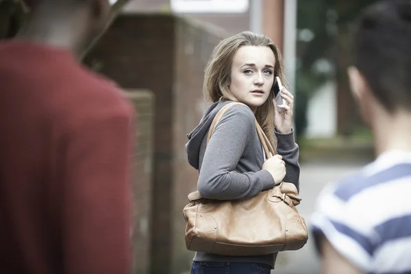 Adolescente usando telefone como ela se sente intimidado na caminhada para casa — Fotografia de Stock