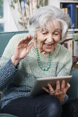 Üst düzey kadın dijital Tablet kullanarak görüntülü arama yapma