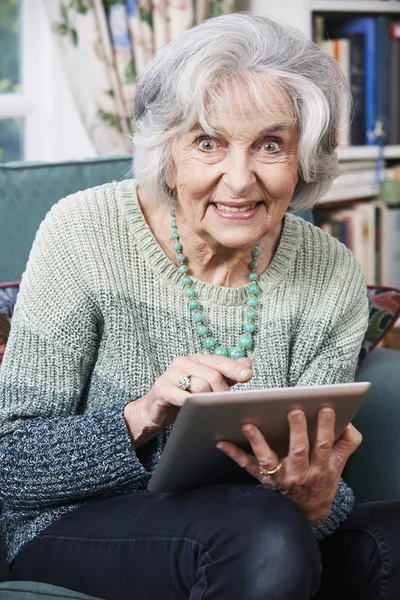 Seniorin nutzt digitales Tablet zu Hause — Stockfoto