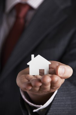 Model ev avucunun içinde tutan işadamı