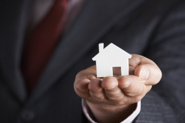 Model ev avucunun içinde tutan işadamı