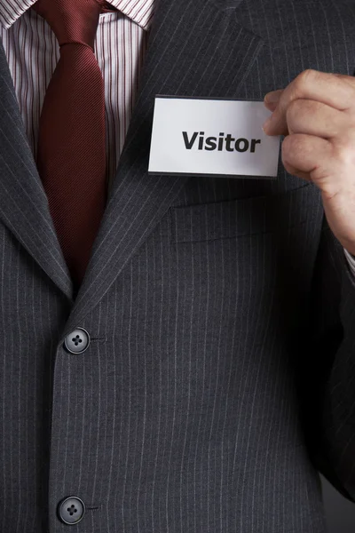 Businessman Attaching Visitor Badge To Jacket — Stock Photo, Image
