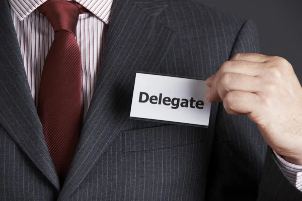 Empresário anexando o emblema do delegado ao casaco — Fotografia de Stock