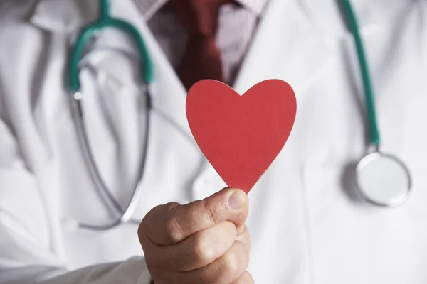 Primer plano del médico sosteniendo el corazón de cartón — Foto de Stock