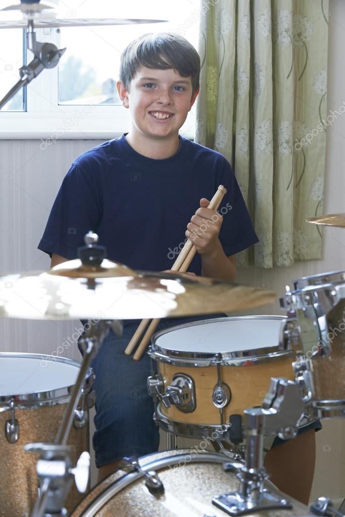 Boy Playing Drum Kit At Home