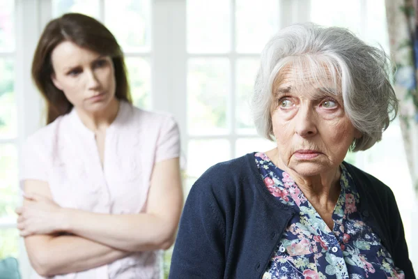 Серьезный пожилая женщина с дочерью взрослого дома — стоковое фото