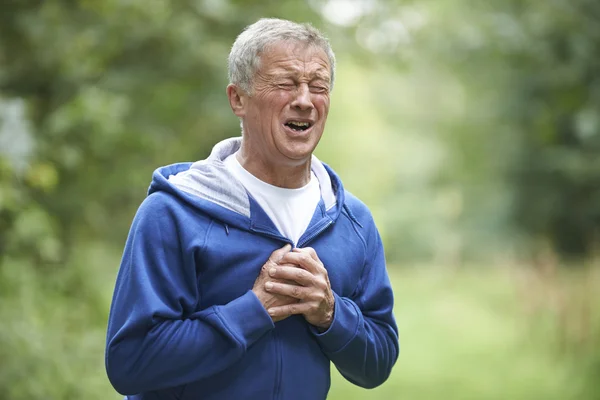 Starší muž trpí srdeční infarkt, zatímco jogging — Stock fotografie