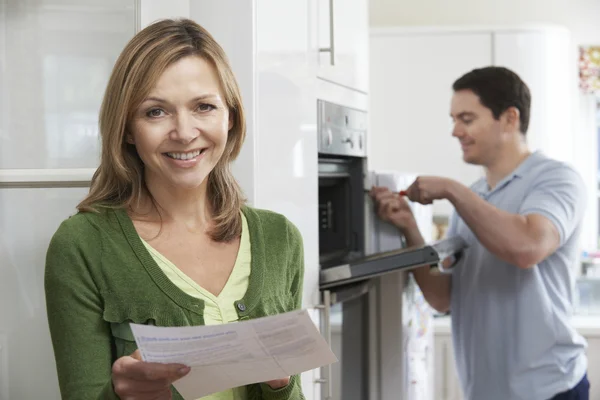Cliente femenino satisfecho con la factura de reparación del horno — Foto de Stock