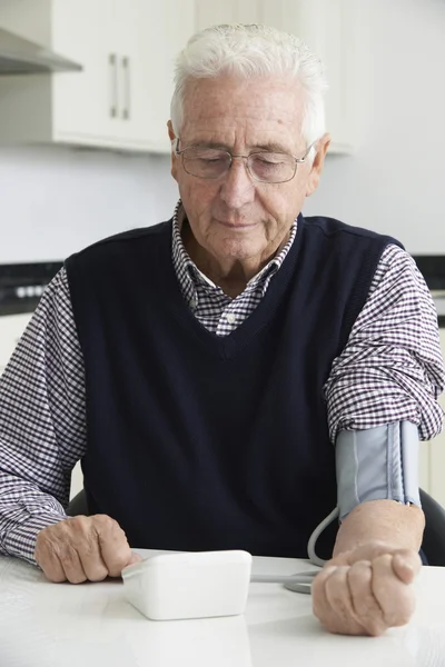 Hombre mayor midiendo la presión arterial en casa —  Fotos de Stock