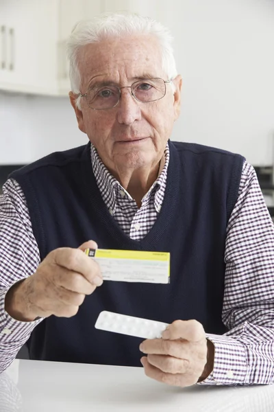 Starší muž čtení informací o drogové balení — Stock fotografie