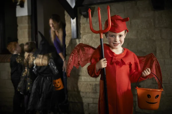 Fiesta de Halloween con niños truco o tratamiento en traje —  Fotos de Stock