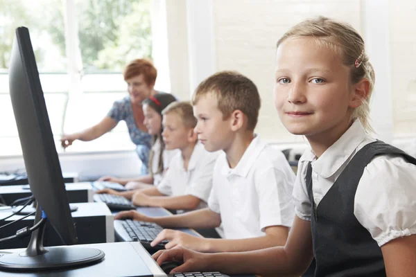 Groep van elementaire leerlingen in computer klas met leraar — Stockfoto