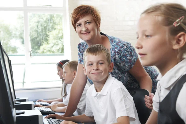 Aluno elementar masculino na classe de computador com professor — Fotografia de Stock