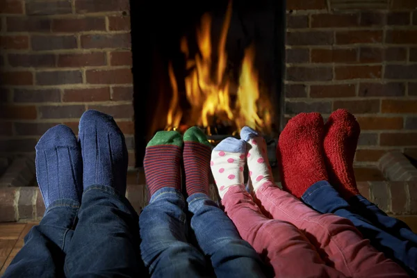 Familia usando calcetines calentando pies por fuego —  Fotos de Stock