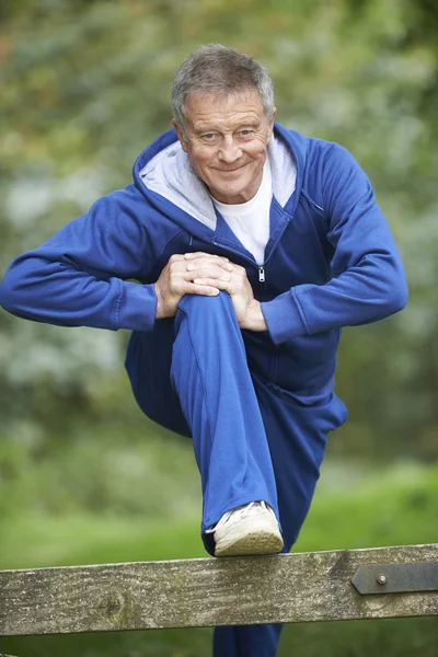 Starší muž táhnoucí se na venkově běh — Stock fotografie