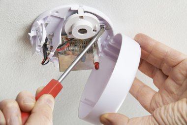 Close Up Of Installing Smoke Detector At Home clipart