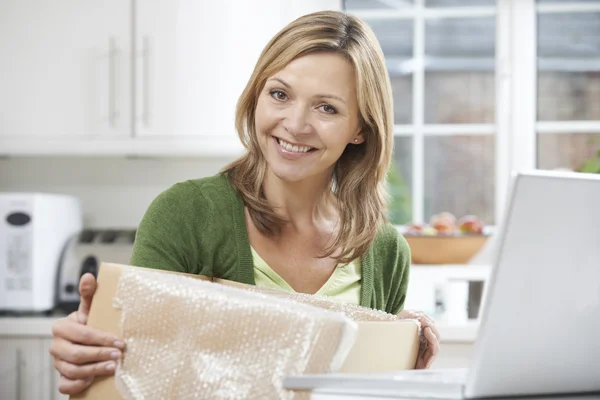 Glückliche Frau packt Online-Einkauf zu Hause aus — Stockfoto