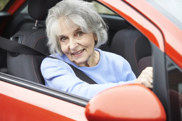 Starší žena řídit auto se usmívám — Stock fotografie