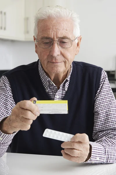 Homme âgé lisant des informations sur l'emballage des médicaments — Photo