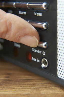 Close Up Of Woman Pressing Standby Button On Radio clipart