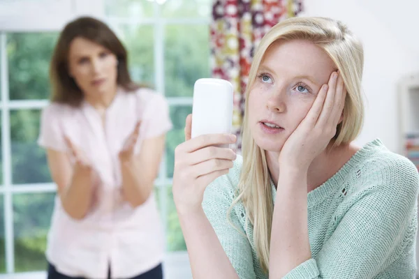 Matka kłócą się z nastoletnią córkę korzystanie z telefonu komórkowego — Zdjęcie stockowe